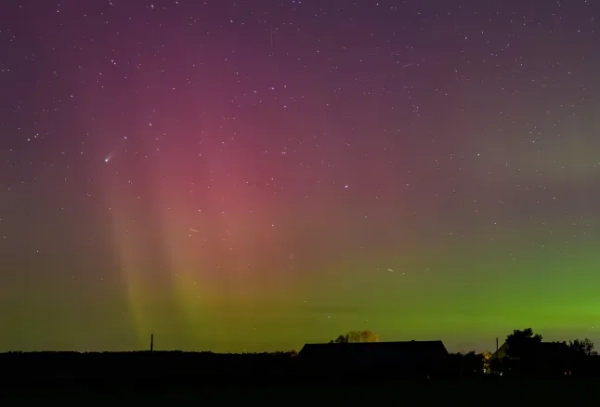 Північне сяйво та комета Леммона C/2025 A6, посередині ліворуч, сяють у нічному небі над ландшафтом у Літцені, Німеччина, пізно в суботу, 18 жовтня 2025 року. Патрік Плеул/dpa via AP)